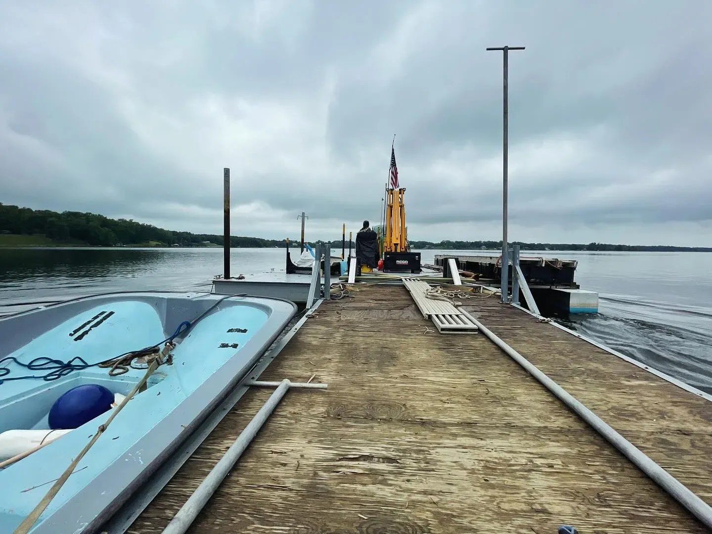 The barge tied up at the end of a pier under a gray sky