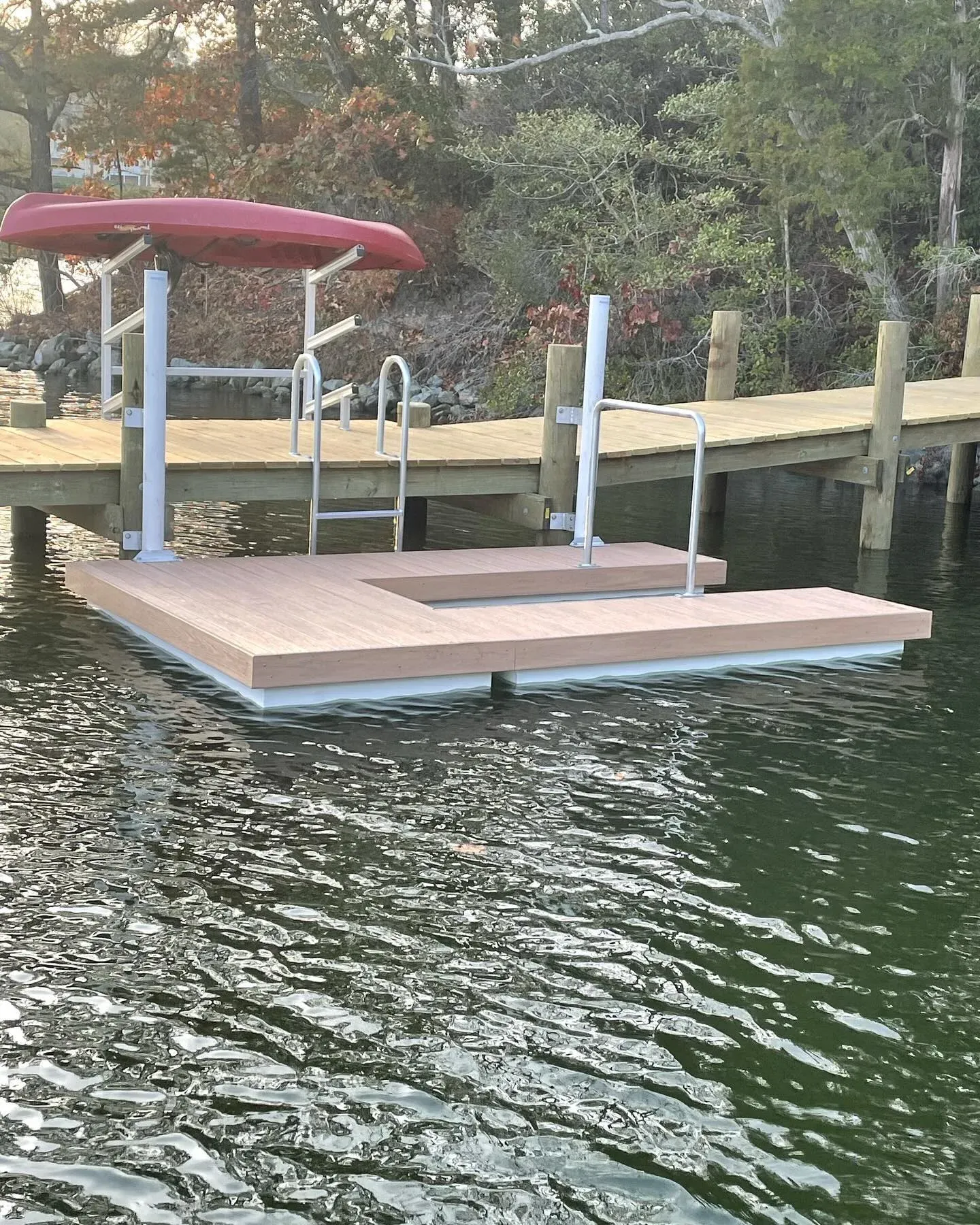 A floating launch with composite decking and grab rails beside a new dock