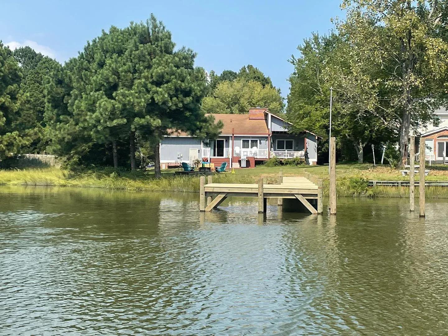 A new pier and platform reaching out from a waterfront lawn