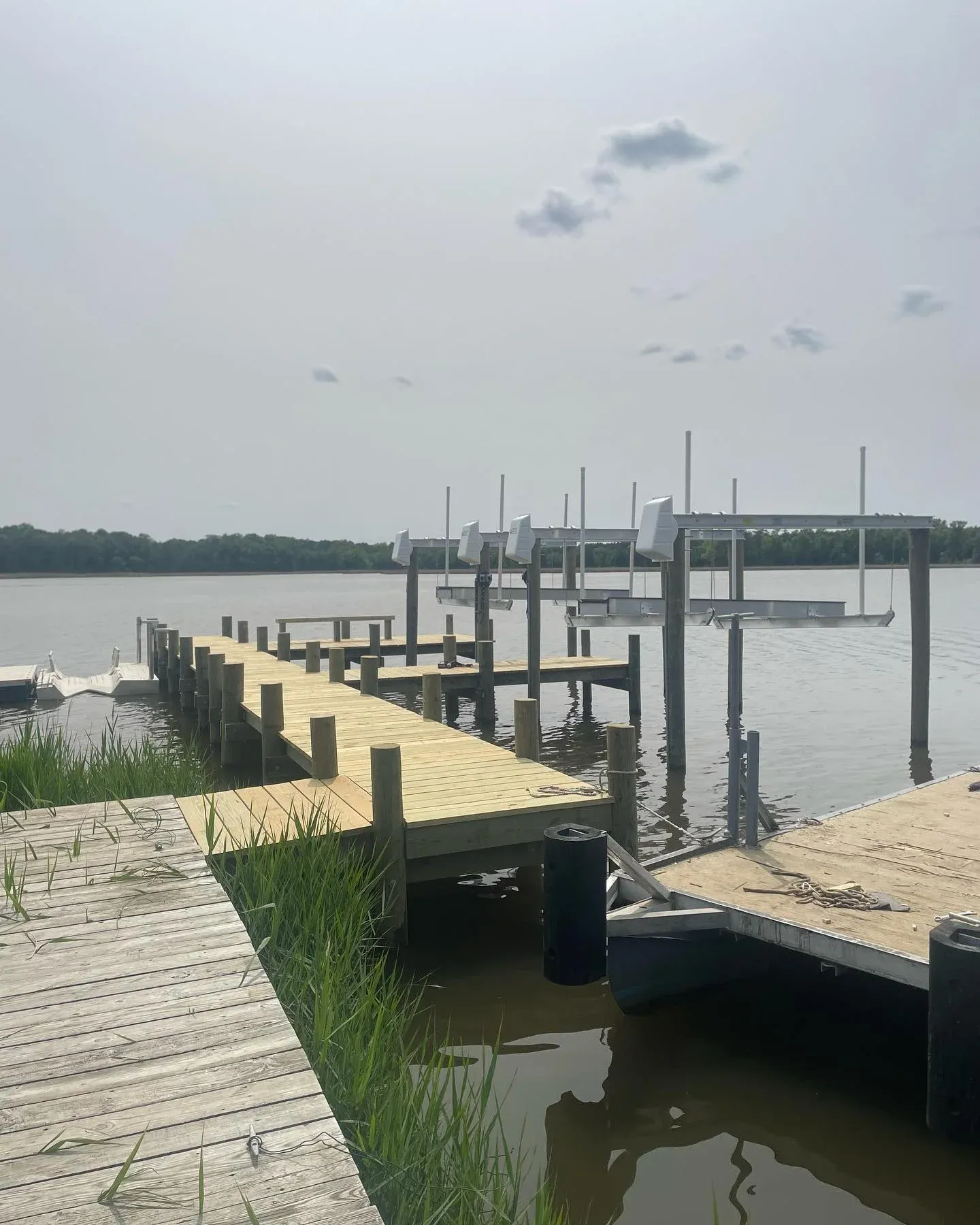A new pier with boat lifts reaching out past the marsh grass